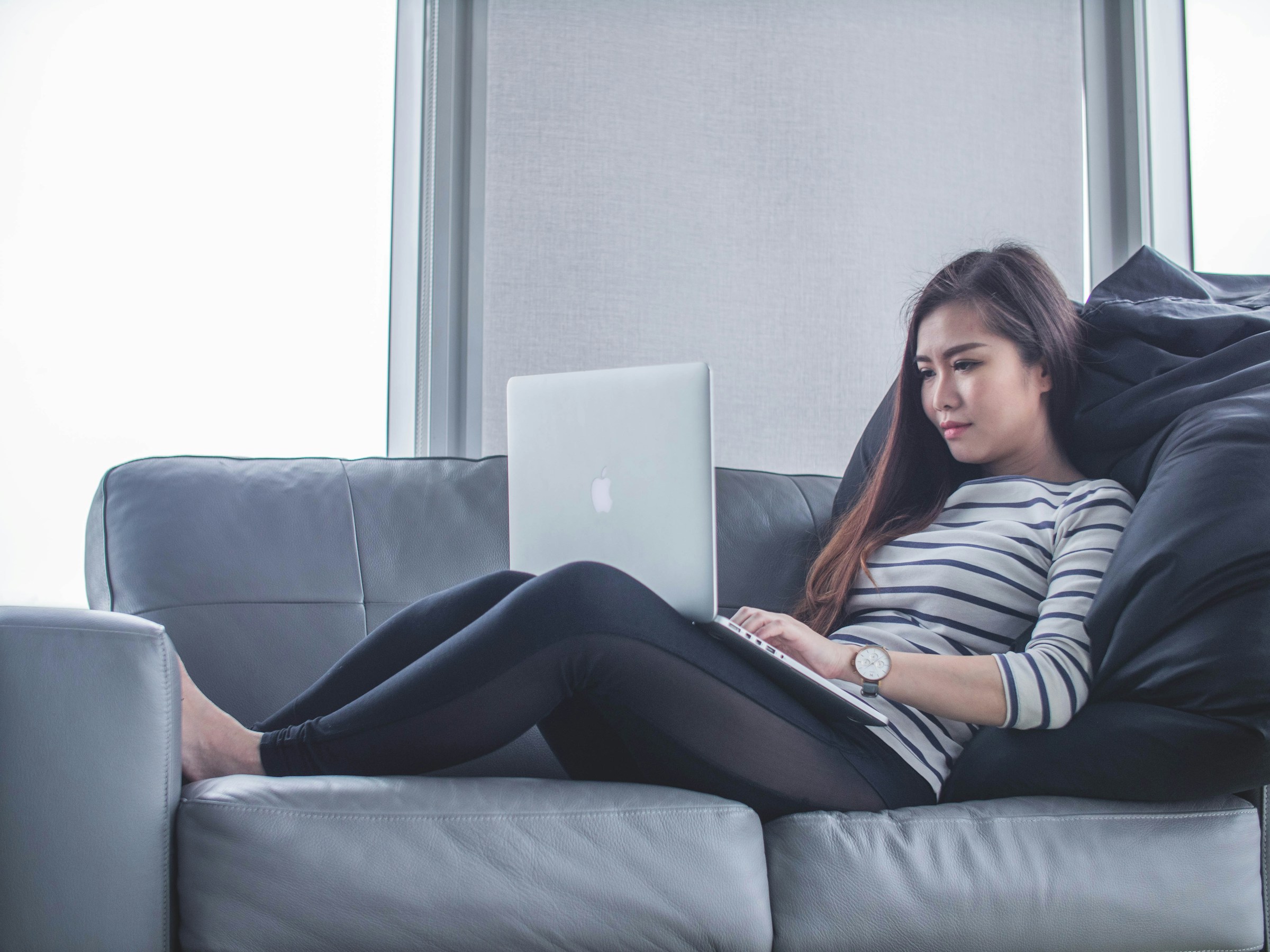 woman sitting on couch and working - Articleforge