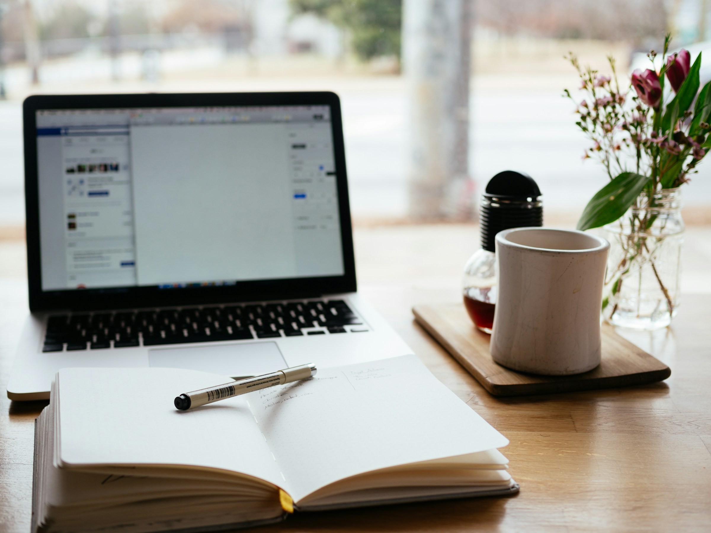 Laptop on Table with Book - AI Content Management