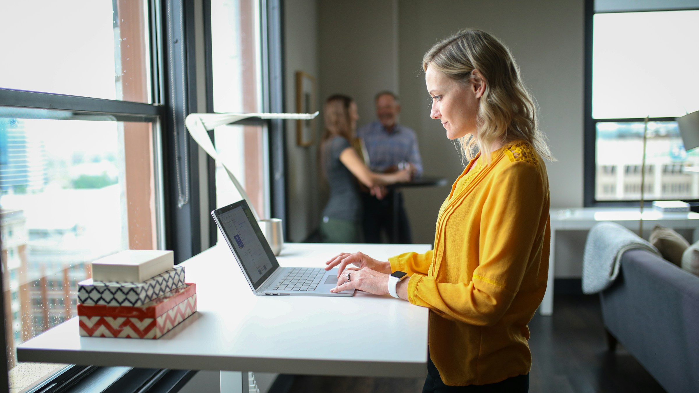 woman standing up and working - Best AI Writing Assistant