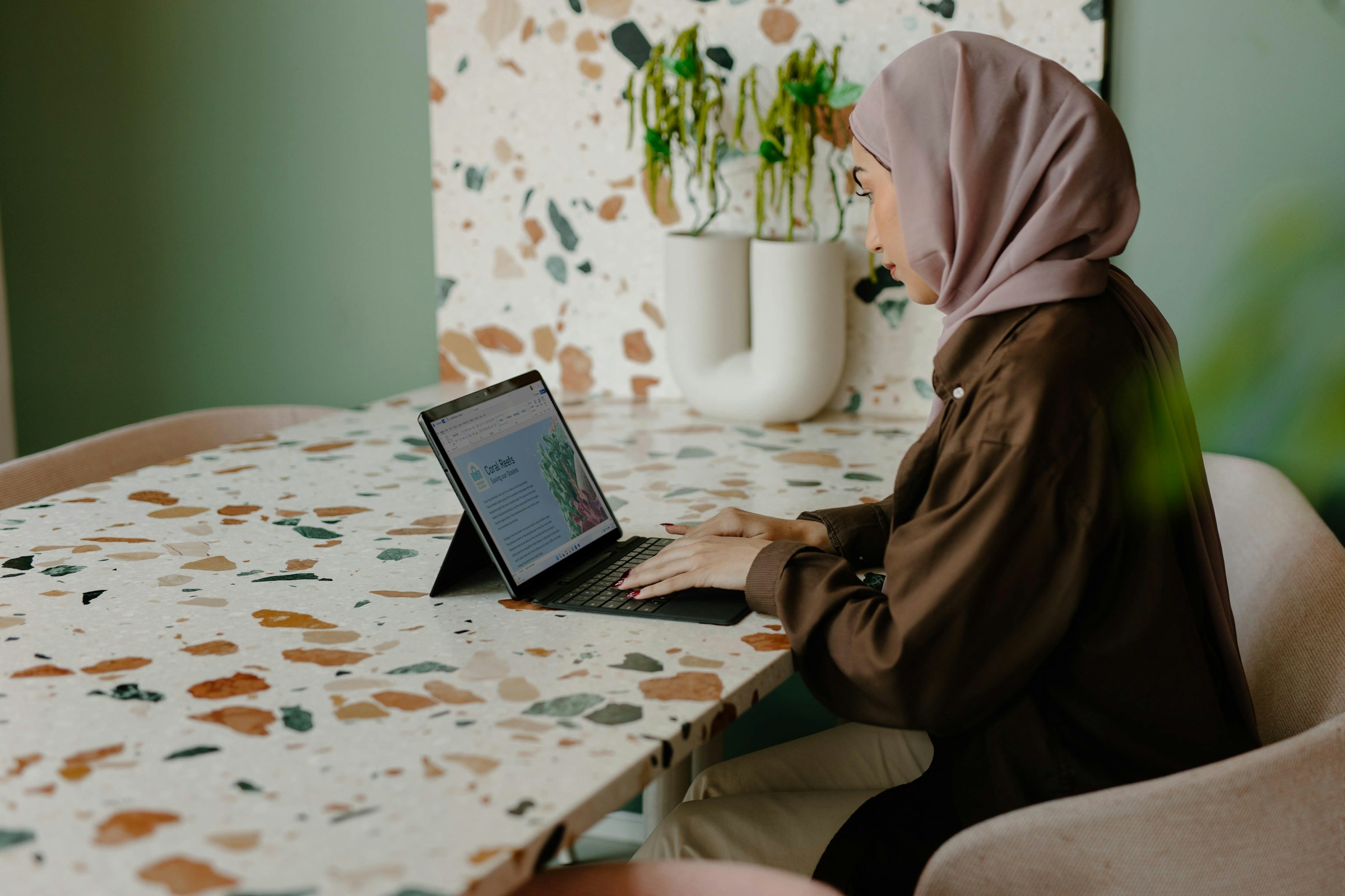 woman infront of laptop in scarf - How To Automate Content Creation